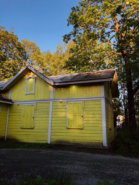 Foto una vieja casita de madera amarilla.