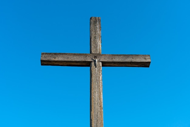 Una vieja cruz de madera contra un cielo azul claro Jesús crucificado en la cruz El concepto del amor puro y no correspondido de Dios Jesucristo por el hombre