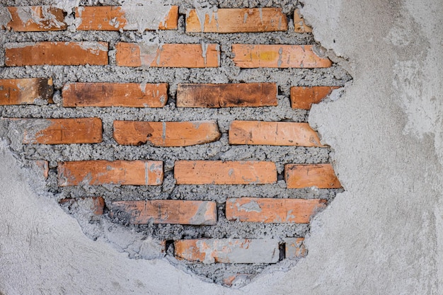 Vieja grieta en la pared de ladrillos rotos dentro del cemento