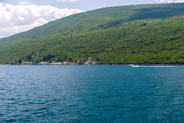 La vieja grúa militar descarga carga en un pequeño puerto de la bahía de BokaKotor Montenegro