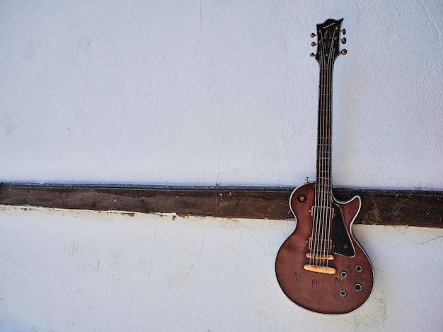 Vieja guitarra colgada en la pared