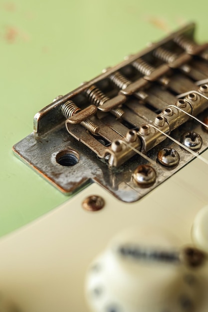 Vieja guitarra verde sobre fondo blanco.