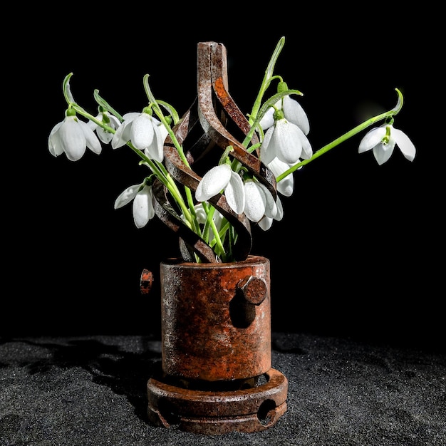 Foto vieja herramienta metálica oxidada y gotas de nieve blancas sobre un fondo negro