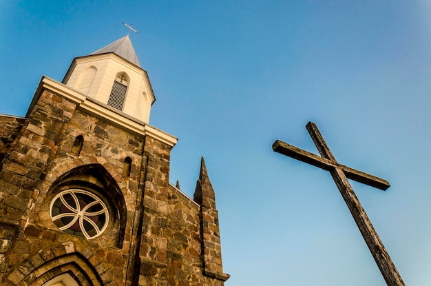 Vieja iglesia vieja cruz de madera contra el cielo