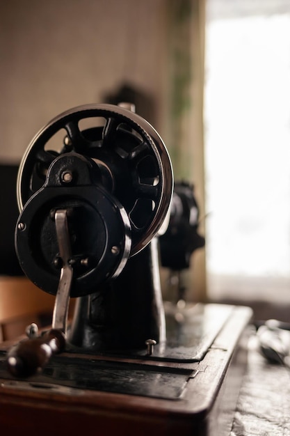 Una vieja máquina de coser está sobre la mesa en casa lista para trabajar y coser y coser.