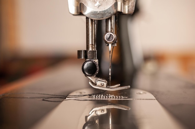 Una vieja máquina de coser está sobre la mesa en casa lista para trabajar y coser Estilo retro clásico