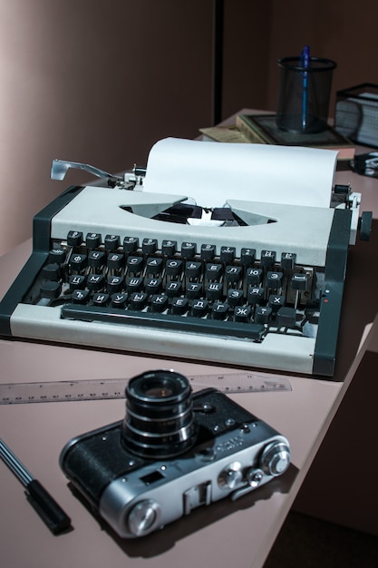 Una vieja máquina de escribir con la cámara sobre la mesa