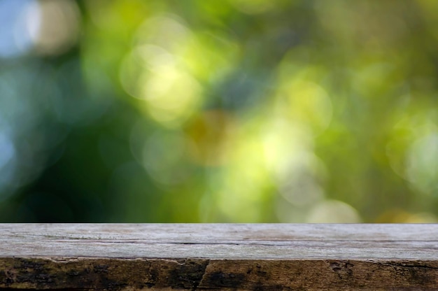 Vieja mesa vacía de madera para exhibir productos frente a un fondo abstracto verde y amarillo