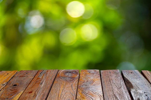 Vieja mesa vacía de madera de teca frente al fondo verde bokeh para mostrar el producto