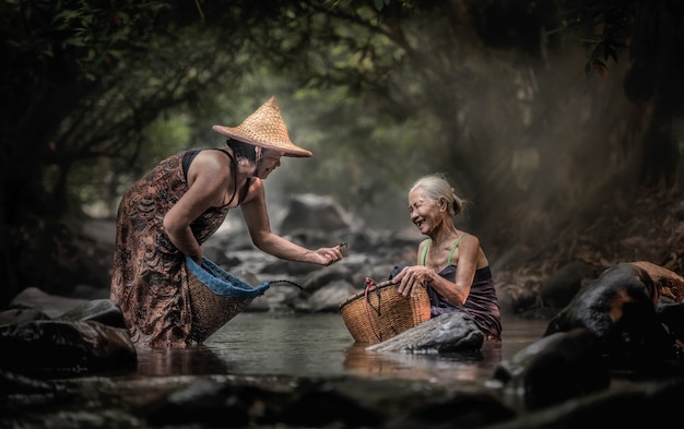 Vieja mujer asiática trabajando en cascada, Tailandia