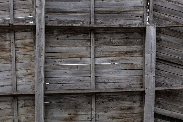 Vieja pared gris de madera seca con estantes de cerca