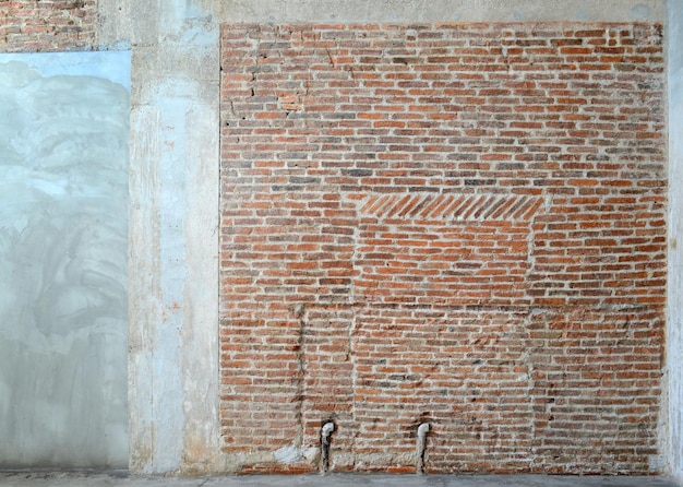 Vieja pared de ladrillo y tubería sobre fondo de textura de hormigón para decorar