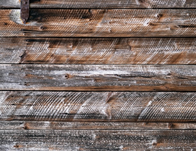 Vieja pared de madera desgastada con tablas horizontales y clavos oxidados