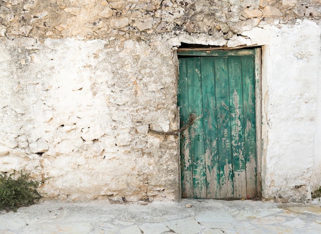 Vieja puerta de madera en mal estado pintada de verde