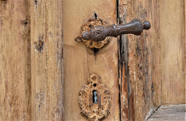 Vieja puerta de madera con pomo de metal y adornos