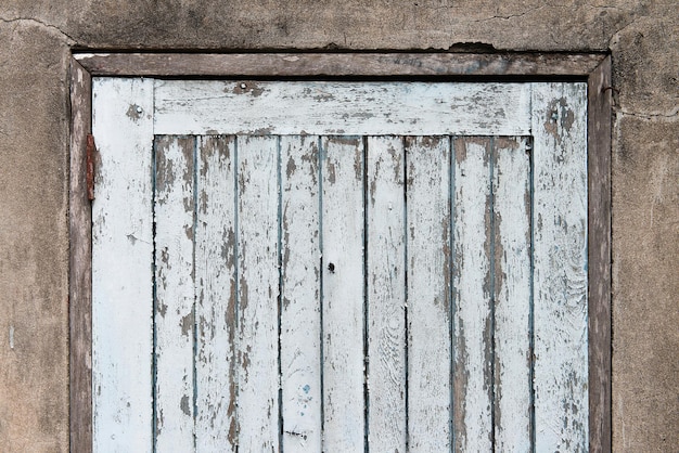 Vieja puerta de tablones de madera con muro de hormigón