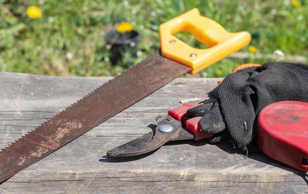 Una vieja sierra de mano oxidada con mango de plástico para tableros de aserrado de madera, madera contrachapada y otros materiales