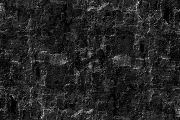 Foto vieja superficie rugosa abandonada de una pared de piedra oscura para el fondo de la textura