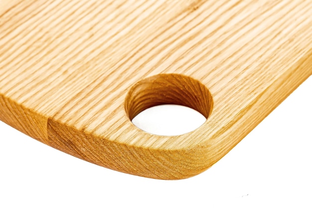 Vieja tabla de cortar de madera rectangular, limpia y vacía, aislada en blanco en una vista oblicua de ángulo bajo para la colocación de alimentos.