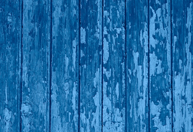 Vieja textura de fondo de madera con capas de pintura, grietas. Tonos en color azul clásico.