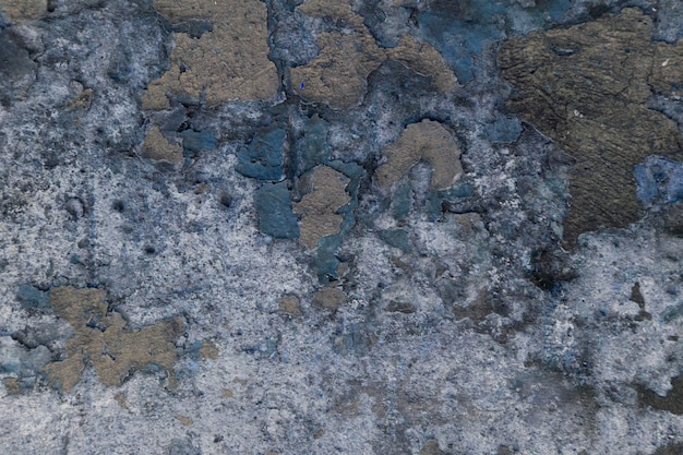 Vieja textura de pared gris con piezas de pintura azul y marrón