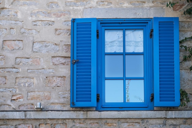 Vieja ventana azul con persianas