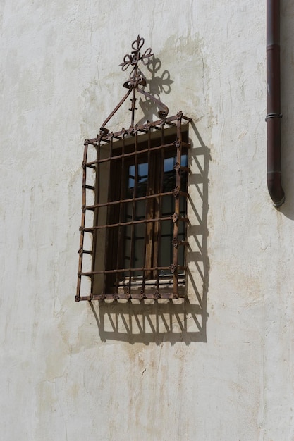 Vieja ventana de hierro con bordes de madera en una calle española. arquitectura tradicional en españa
