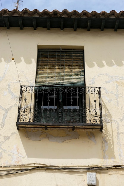 Vieja ventana de hierro con bordes de madera en una calle española. arquitectura tradicional en españa