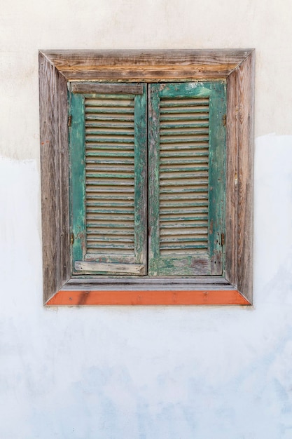 Vieja ventana de madera con persianas de celosía cerrada Vertical