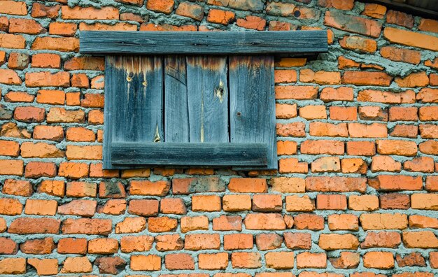 Una vieja ventana tapiada en una pared de ladrillos.