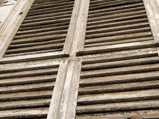 Viejas persianas de madera en la ventana Arquitectura de madera antigua Madera seca con pintura descolorida susurrante Cáscara y polvo Color natural Alféizar de la ventana listones y rayas horizontales