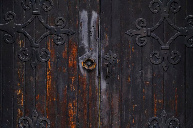 Viejas puertas góticas de madera con piezas de metal forjado y mango