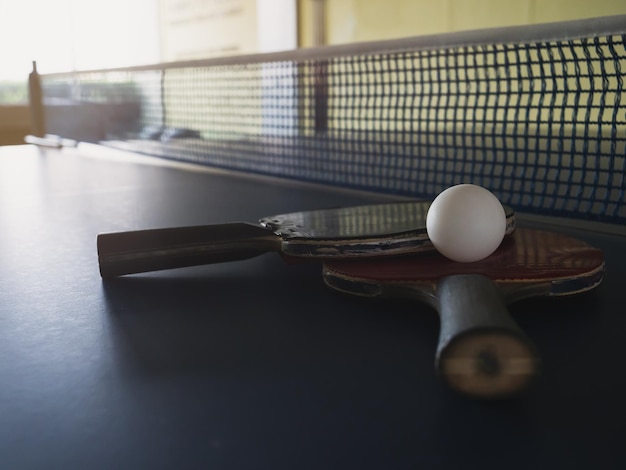 Foto viejas raquetas y bolas de tenis de mesa colocadas en tenis de mesa