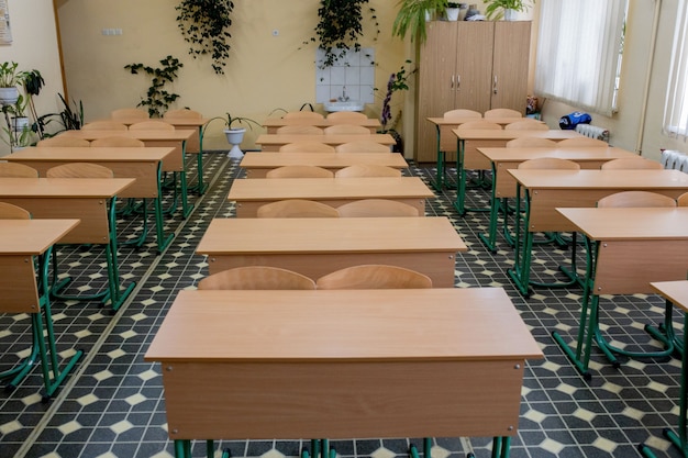 viejas sillas de conferencia de fila de madera en el aula en la escuela pobre