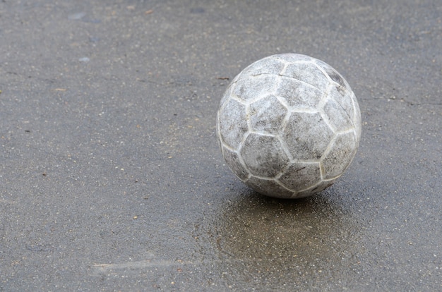 Foto viejo balón de fútbol en piso de cemento