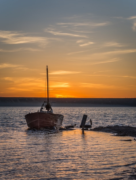 Foto viejo barco abandonado al atardecer