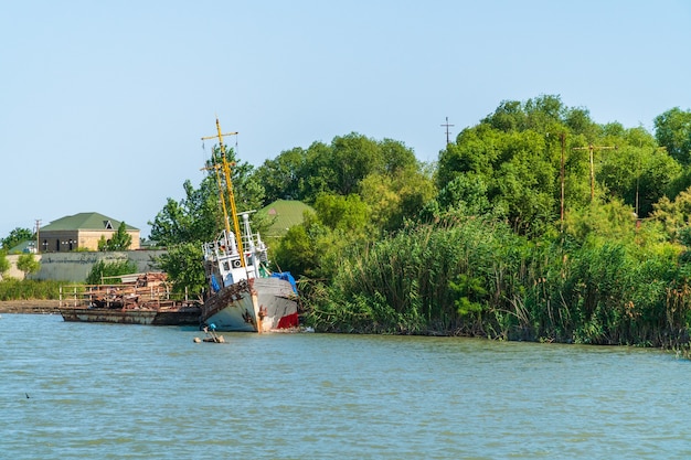 Viejo barco abandonado en la orilla del río