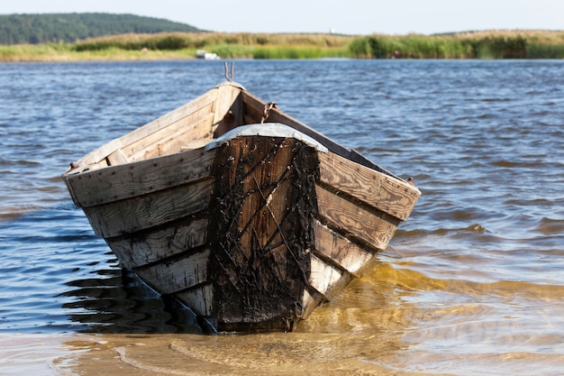 Viejo barco de madera con viejos artes de pesca para pescar, antiguo pueblo abandonado