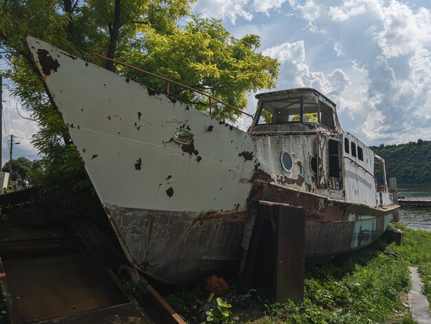 Un viejo barco oxidado en la orilla del río