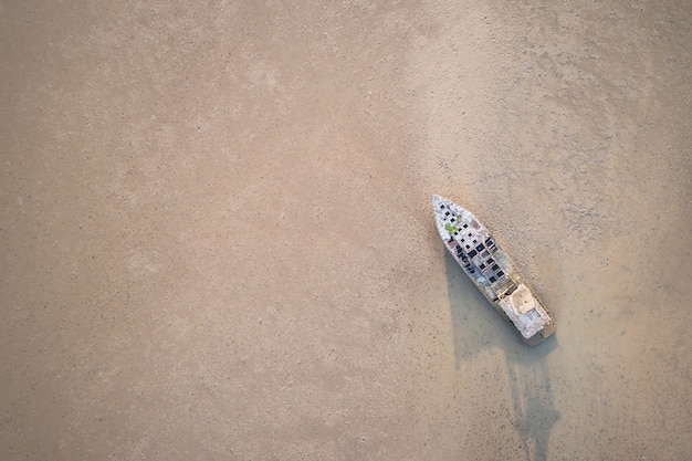 Foto viejo barco de pesca de pie en el mar de barro