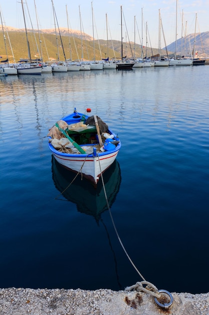 Viejo barco de pescadores con yates modernos en el muelle