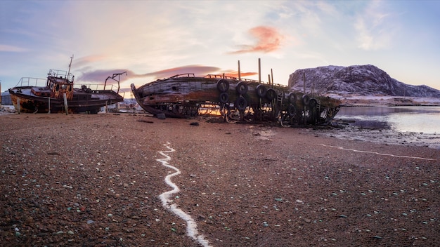 Un viejo barco pesquero oxidado abandonado por una tormenta en la orilla. Cementerio de barcos, antiguo pueblo de pescadores en la orilla del mar de Barents, la península de Kola, Teriberka, Rusia.