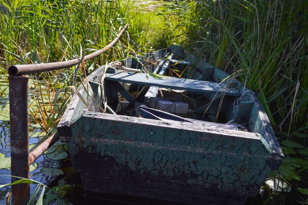 Viejo barco roto de madera en mal estado para nadar en las orillas del mar del lago del río