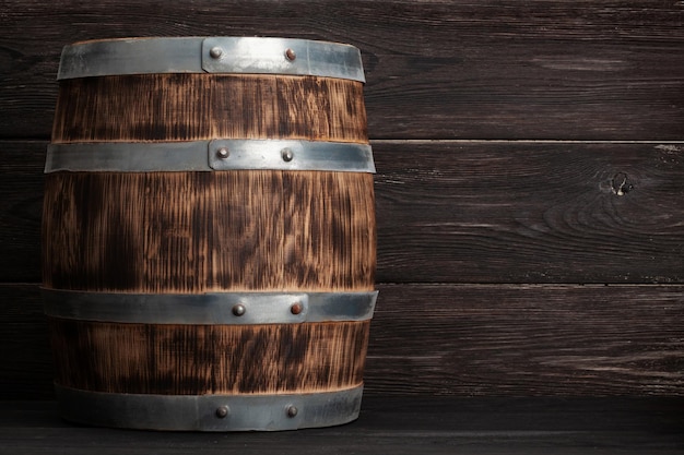 Foto viejo barril de madera para el envejecimiento de vino o whisky frente a una pared de madera con espacio para copiar