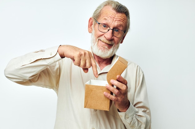 Viejo con una caja en sus manos en estudio solo