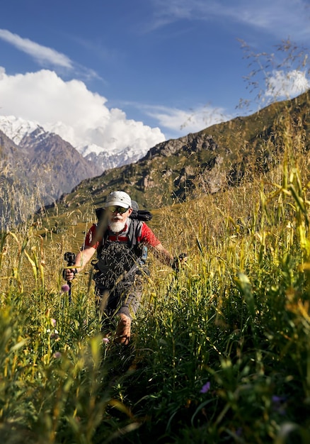 Viejo caminante con mochila en las montañas