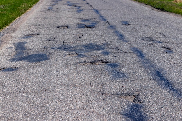 Un viejo camino pavimentado con muchos agujeros y daños