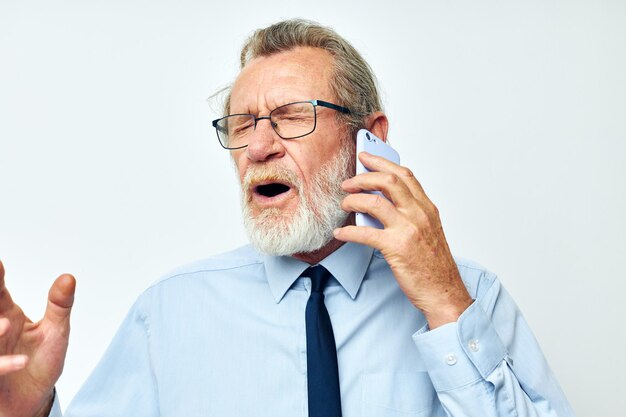 Viejo en una camisa con corbata hablando por teléfono vista recortada