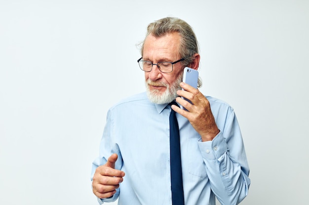 Viejo en una camisa con corbata hablando por teléfono vista recortada