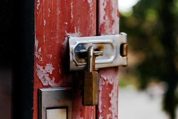 Foto el viejo candado oxidado de la puerta roja